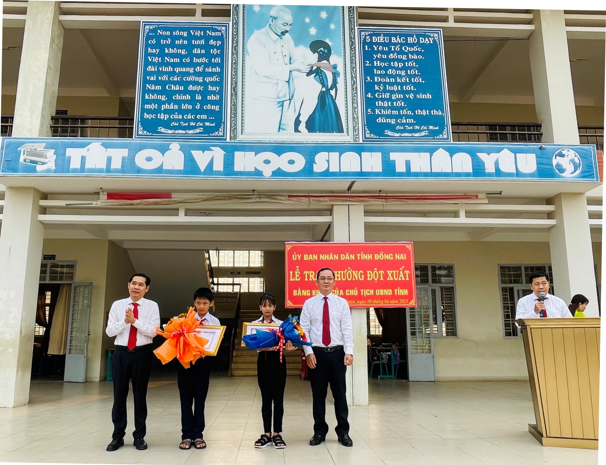 Lãnh đạo Sở Nội vụ và Ban Thi đua - Khen thưởng tỉnh Đồng Nai trao tặng bằng khen và hoa cho 2 em.jpg