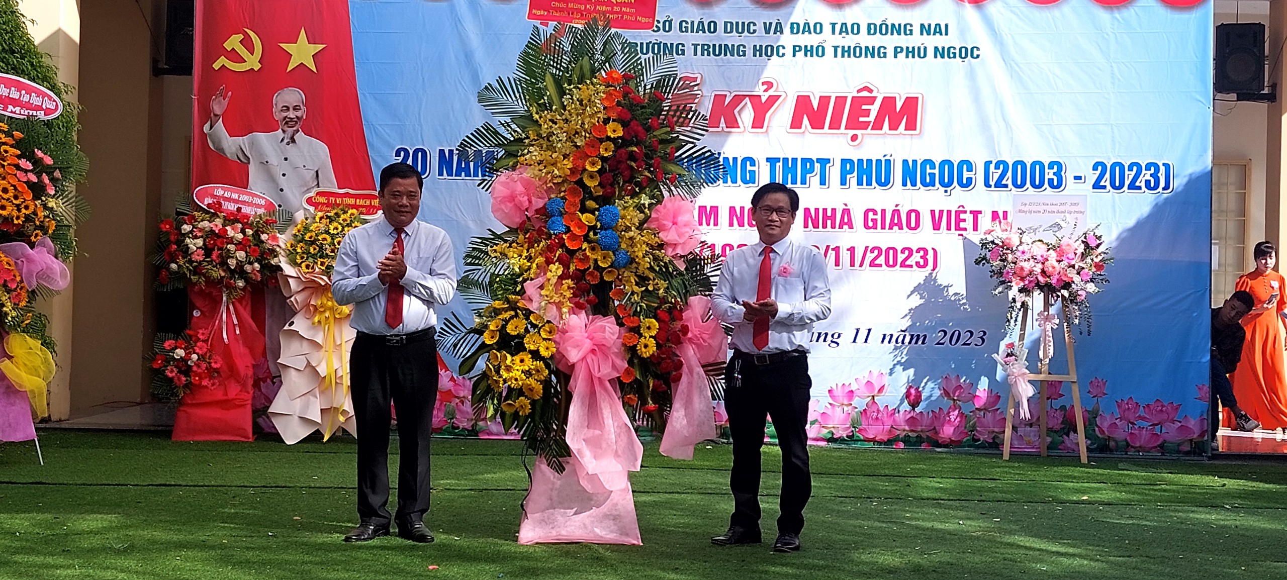 Ông Trần Hữu Hạnh - Phó bí thư TT Huyện ủy, Chủ tịch HĐND huyện Định Quán (Bên trái) trao tặng lẵng hoa chúc mừng nhà trường.jpg